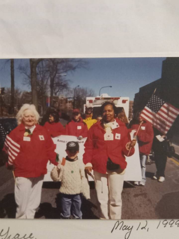 grace and volunteers holding american flag in parade