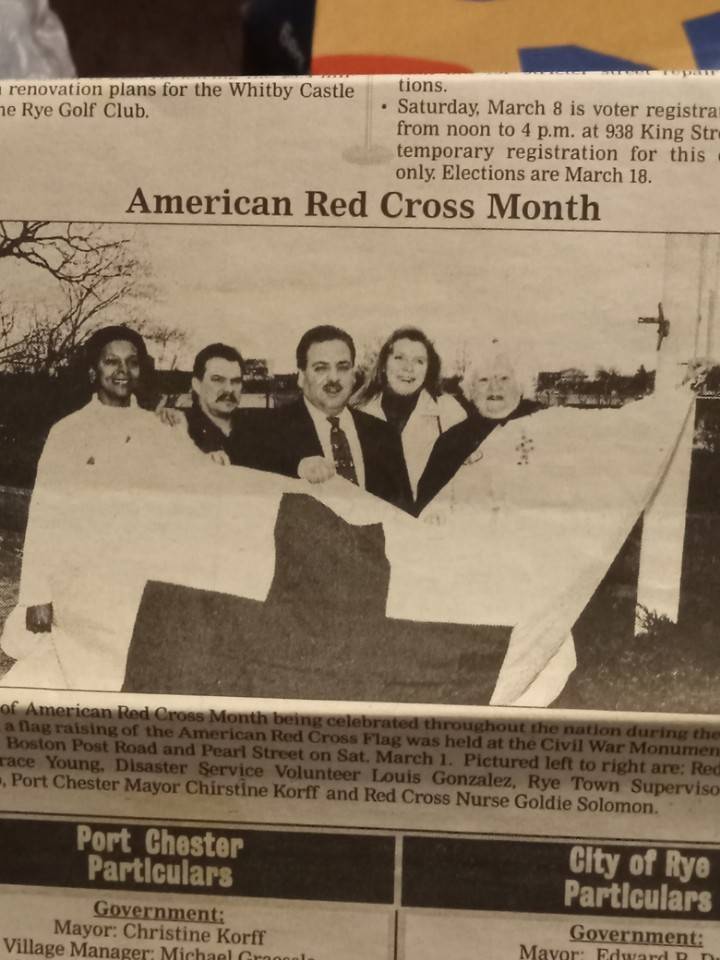 red cross volunteers holding red cross flag in newspaper article