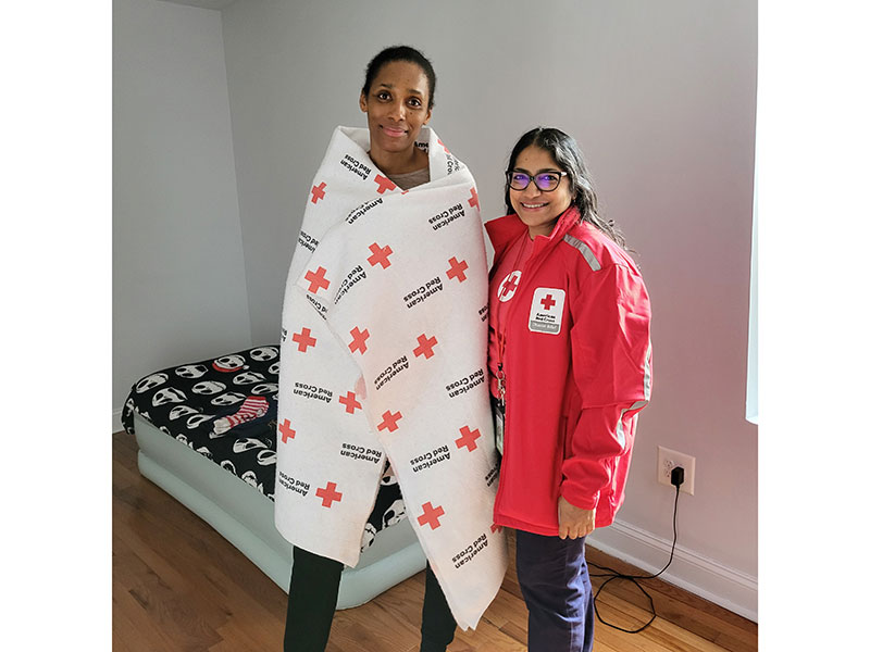 Lallita Maharaj and Martha Richardson pose in Martha's new bedroom with Red Cross blanket