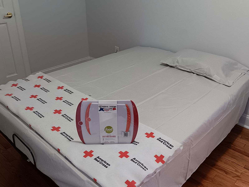 Bed adorned with a Red Cross blanket