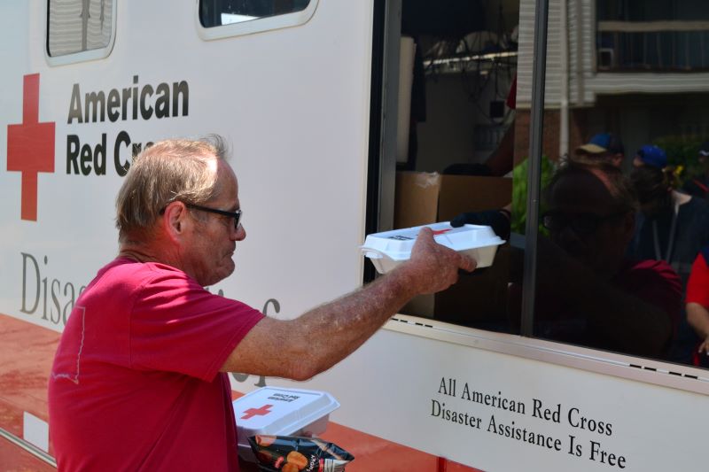  Donald Johnson collects meals of pulled pork sandwiches in barbecue sauce, corn, fruit and potato chips for himself and some of his homebound neighbors from a Red Cross volunteer parked in the Tulsa Pythian Manor parking lot.