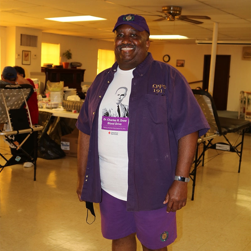 Harry Willis wearing purple hat, shirt and shorts.