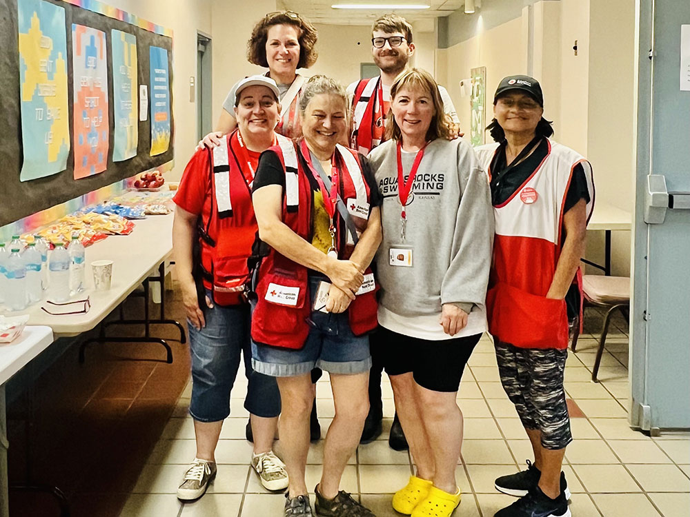 Group of six Red Cross volunteers wearing Red Cross vests and badges.