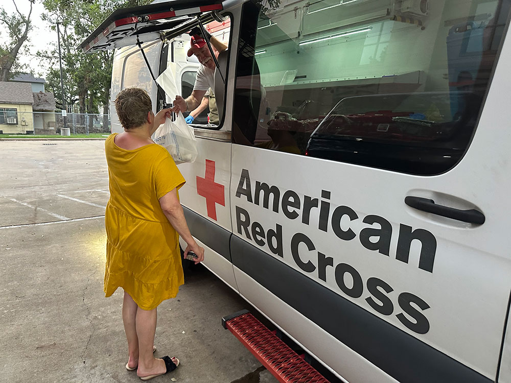 Woman receiving food from American Red Cross van.