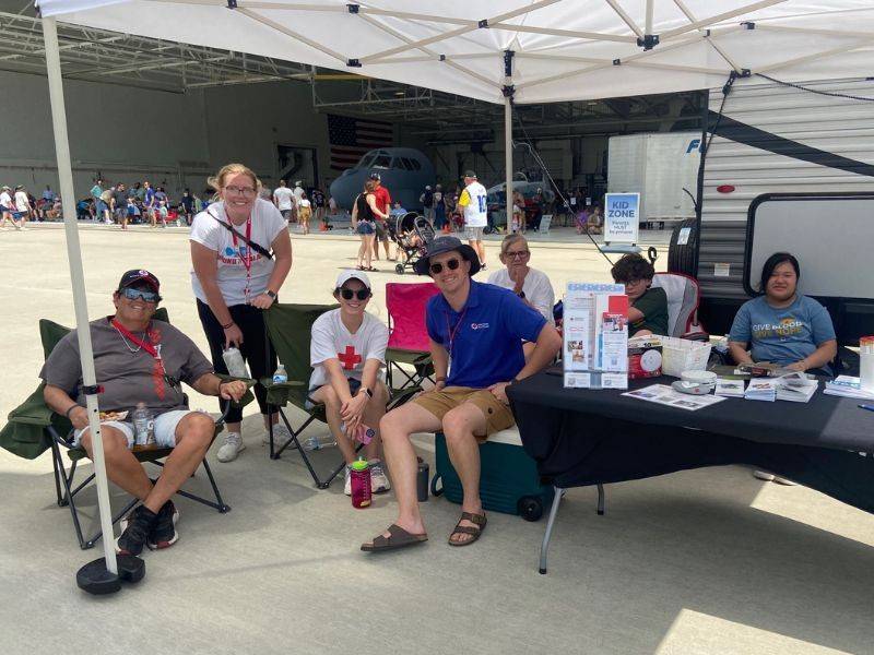 volunteers outside sitting underneath tent