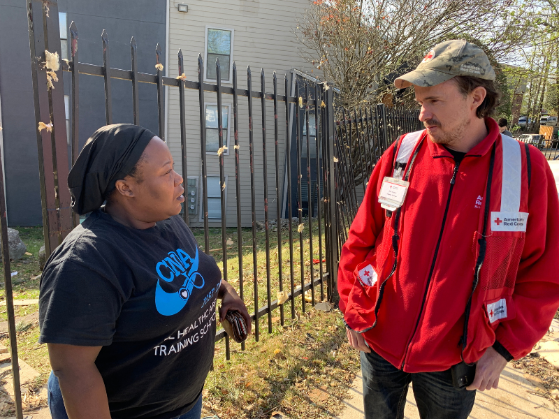 red cross volunteer speaking with resident