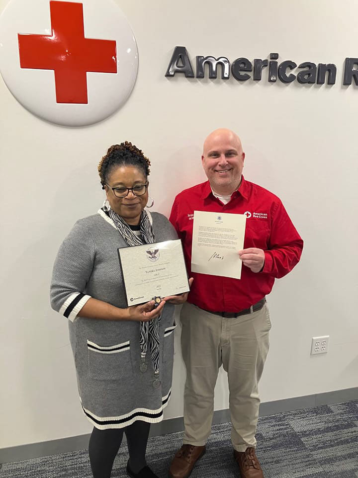 Sandra Johnson and Red Cross employee posing with award