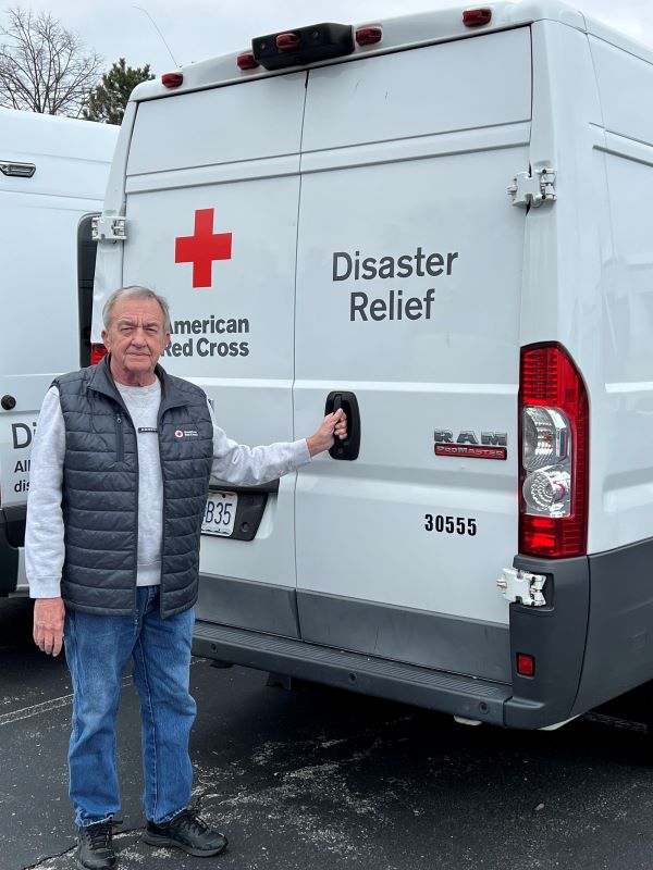 Randy Whitehead smiling next to red cross truck