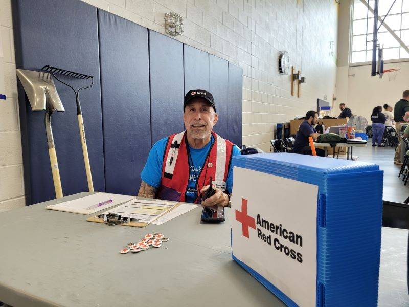 Joe Mauro wearing a red cross vest smiling