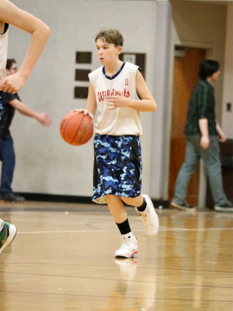 Avery MacNair dribbling the basketball in a school basketball game
