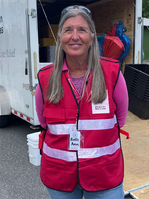 Beth Ann Finlay wearing an American Red Cross vest and smiling for camera.