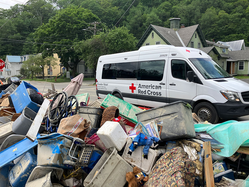 Red Cross Disaster Relief van dring past trash on the side of the road.