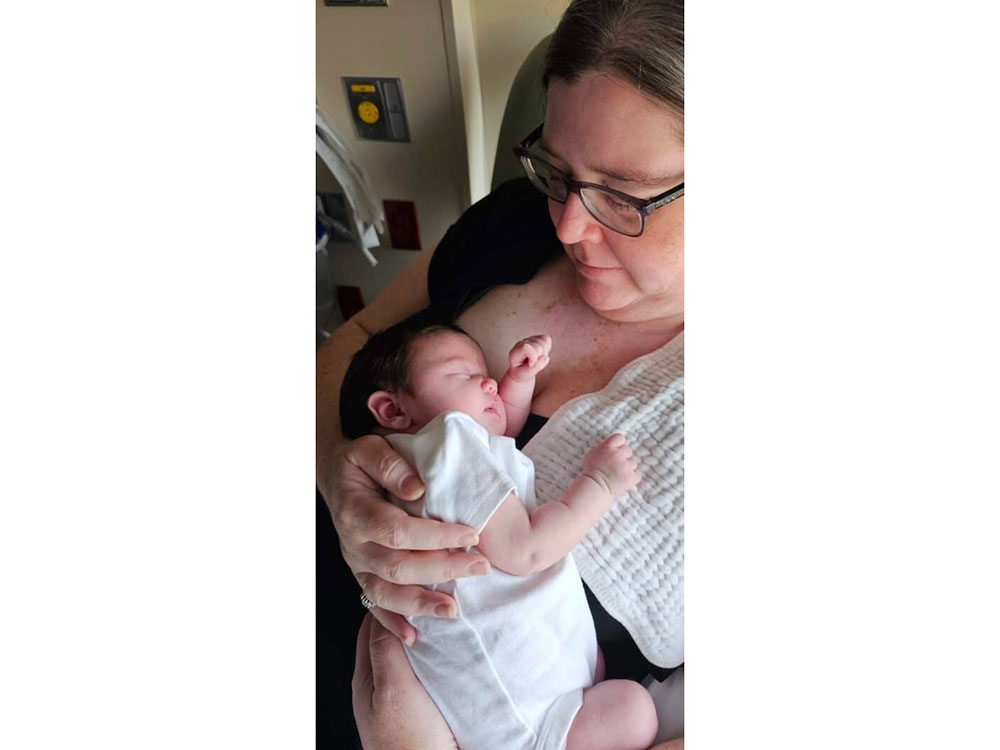 Kerrin Lucas holding sleeping baby close to her