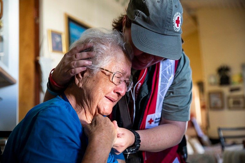Voluntario de la Cruz Roja abrazando a un cliente.