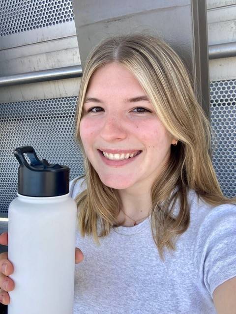Ana Roberts holding white reusable water bottle. 