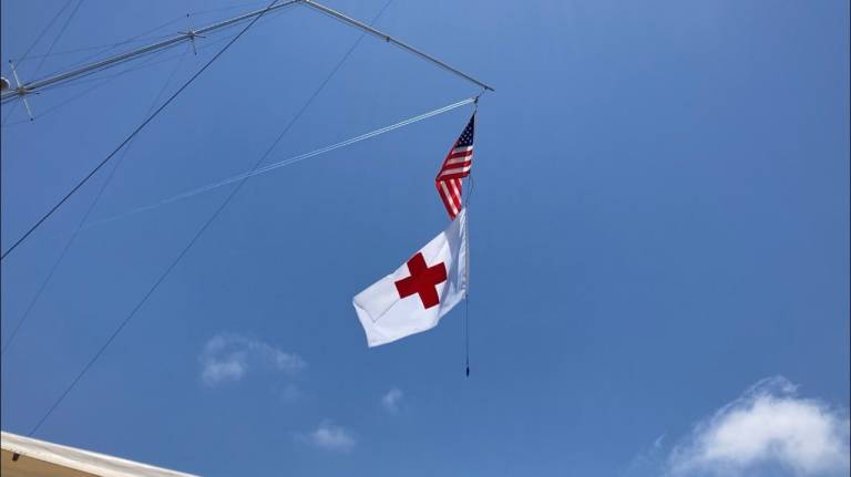 Red Cross flag flies on boat