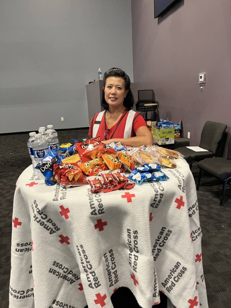 Woman seated in front of table of snacks 