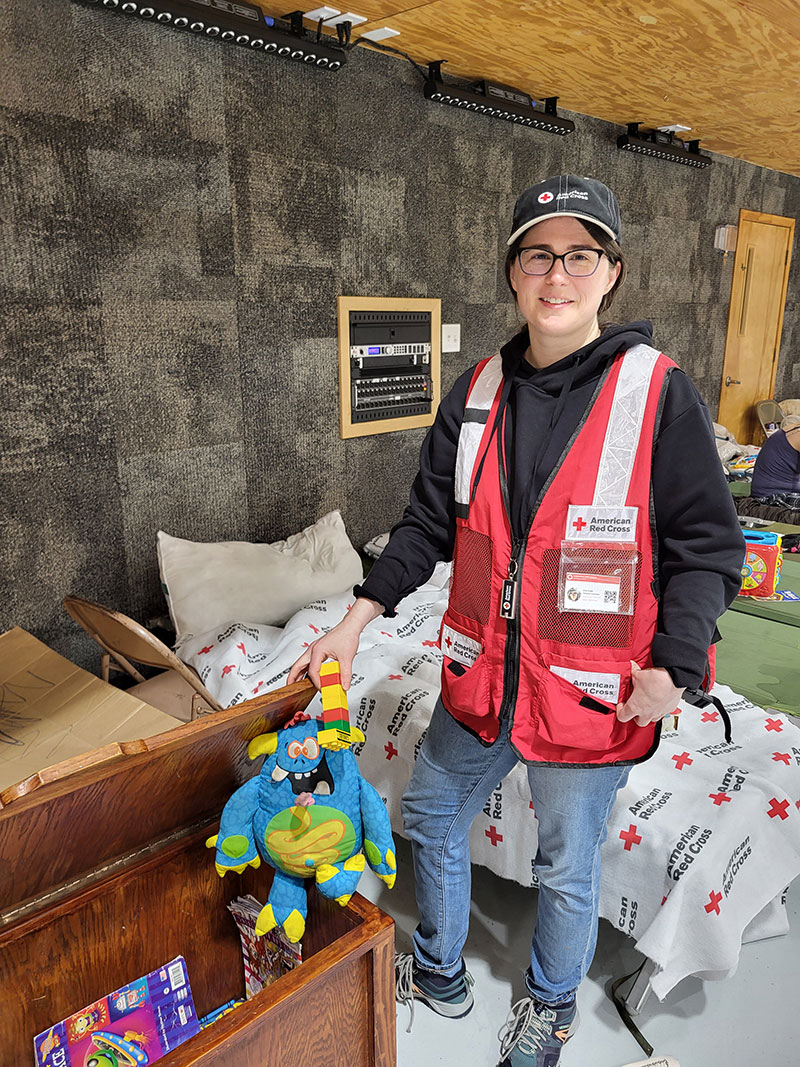Red Cross volunteer Erin Funk puts away children’s toys at emergency shelter