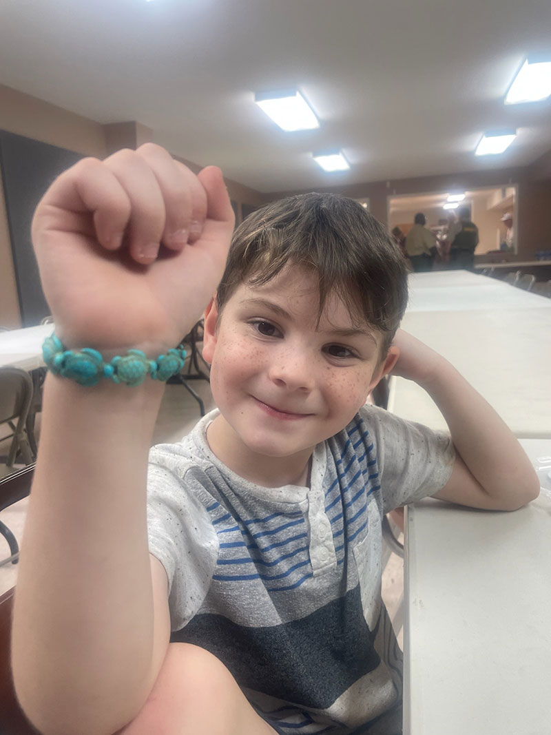 Boy smiling showing bracelet on his wrist