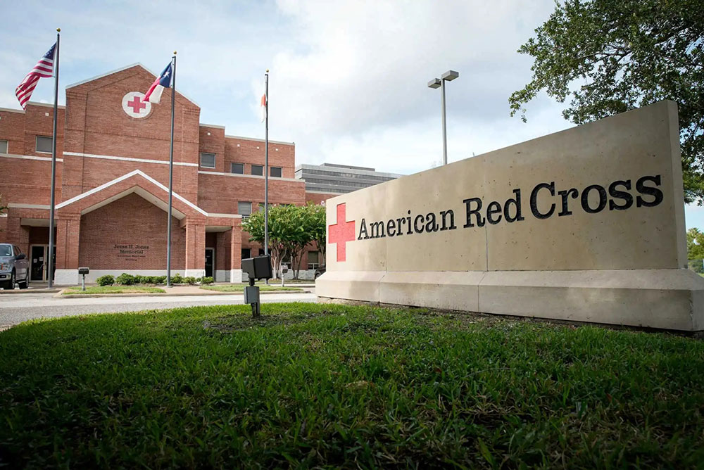 Front of American Red Cross brick building with American, Texas and Red Cross flags.