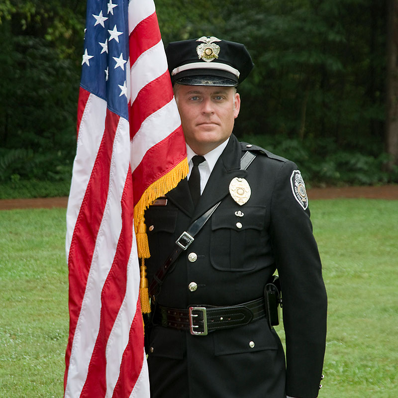 Sgt. Dale Nix in uniform standing next to American flag.