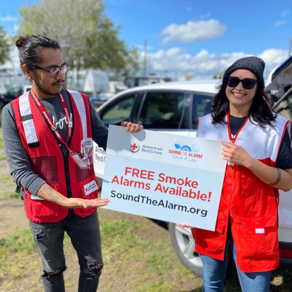 volunteers holding free smoke alarm signage