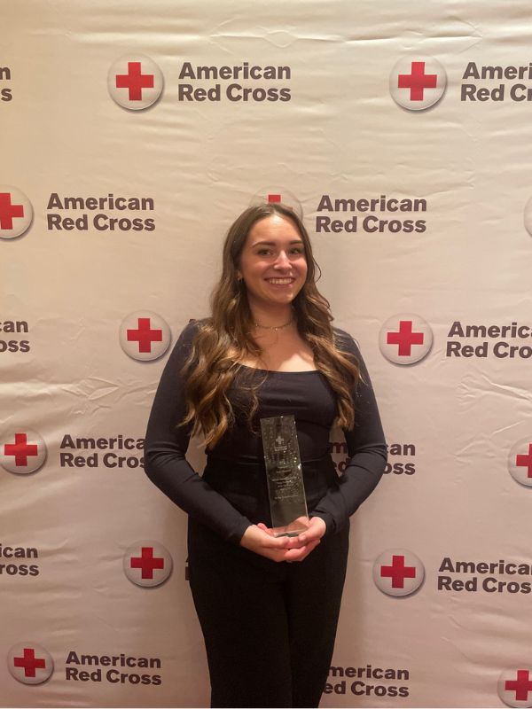 dana woodruff holding red cross award