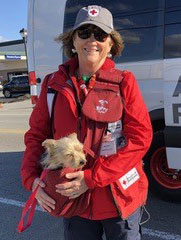 Mary Nichols holding dog in Red Cross outfit