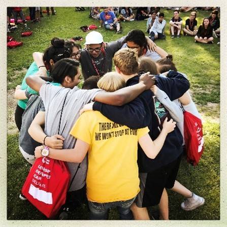 group of red cross youth volunteers huddling in a circle