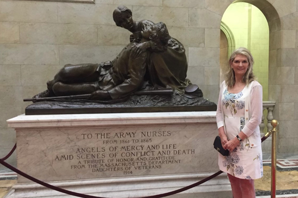 Laurie Laidlaw Deacon standing next to the Army Nurses statue.