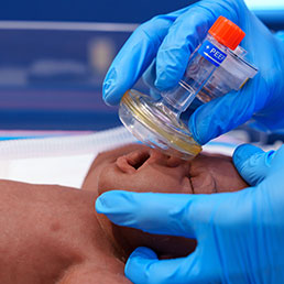 Medical professional applying neonatal resuscitation techniques.